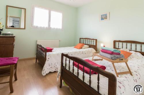 une chambre avec deux lits et un miroir dans l'établissement Gîte aux papillons, à La Garde