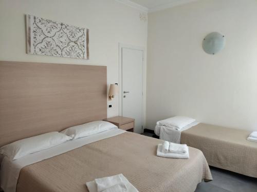 a bedroom with two beds with towels on a table at Hotel Garisenda B&B - in Centro a Riccione - in Riccione