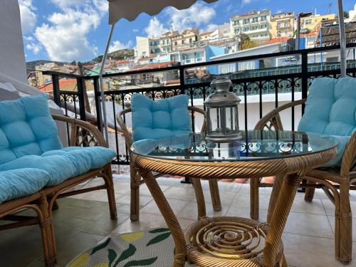 a glass table and chairs on a balcony with a view at Aegean Blu Port House Pythagoreio in Pythagoreio