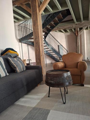 un salon avec un canapé et une chaise dans l'établissement Le pressoir de Nestor, à Monthelon