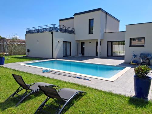 une maison avec une piscine dans l'arrière-cour dans l'établissement location villa moderne piscine, à Mâcon