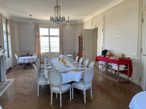 a dining room with a long table and chairs at Château du Mont de Guny in Guny