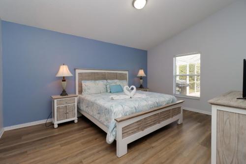 a bedroom with a large bed with blue walls at Quiet Getaway Nr Golf & Posner Park with Pool in Davenport
