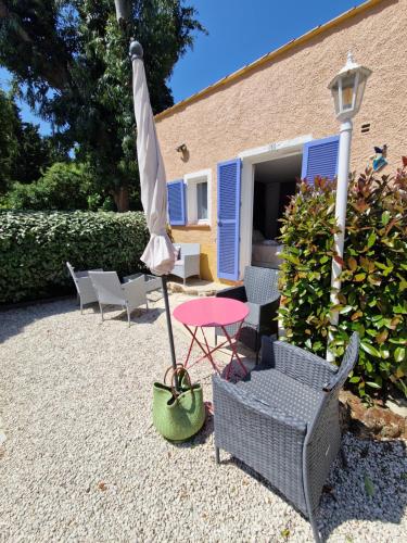 a patio with a table and an umbrella and chairs at Le Cosy in Saint-Aygulf