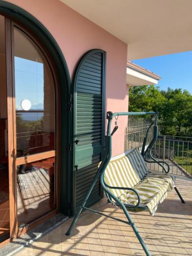 a swinging chair on a porch with a window at B&B Girasole in Torraca