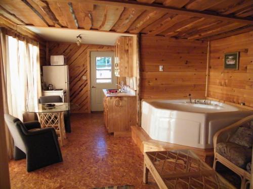 a kitchen with a large tub in a room at Mowat Landing Cottages in New Liskeard