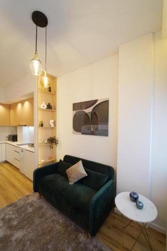 a living room with a green couch and a table at Crystal Palace Oporto Flat - With Two Bedrooms in Porto