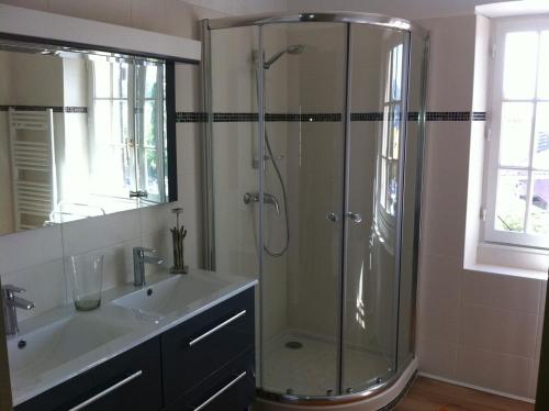 une salle de bain avec une douche en verre et un lavabo dans l'établissement la plage en face , 2 chambres clim parking, au Pradet