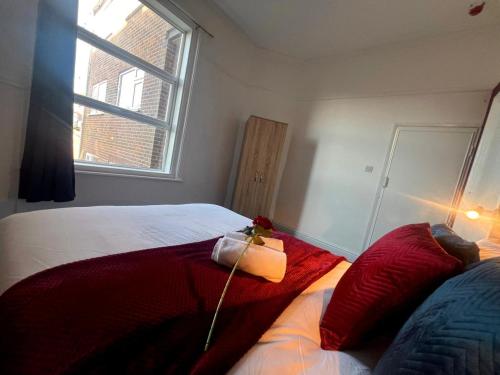 a bedroom with a bed with red pillows and a window at Modern 2 bedrooms apartment Skegness F3 in Skegness
