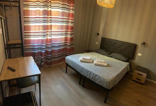 a small bedroom with a bed and a table at Riva Reno 4 Rooms in Bologna