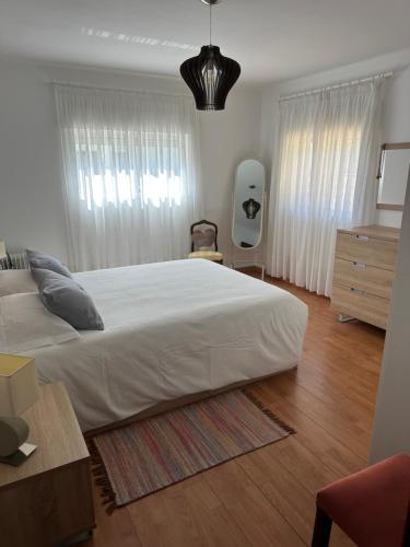 a bedroom with a large white bed and a dresser at Maison de village 3 CHAMBRES in Souto Sico