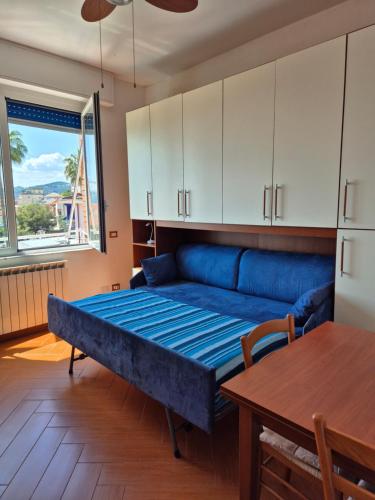 a living room with a blue couch and a table at Appartamento La Casetta in Varazze