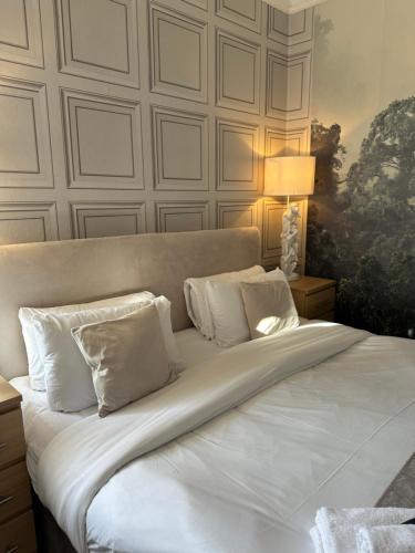 a bed with white sheets and pillows in a room at The Q Hotel in Shanklin