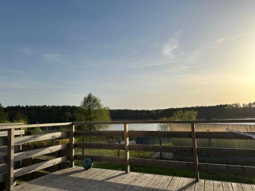 a wooden deck with a fence and a body of water at Monialuki in Nogat