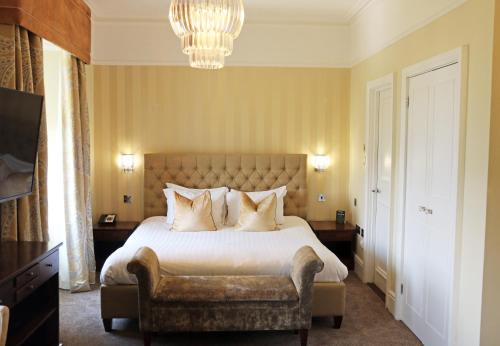 a bedroom with a large bed and a chandelier at The Belsfield Hotel in Bowness-on-Windermere