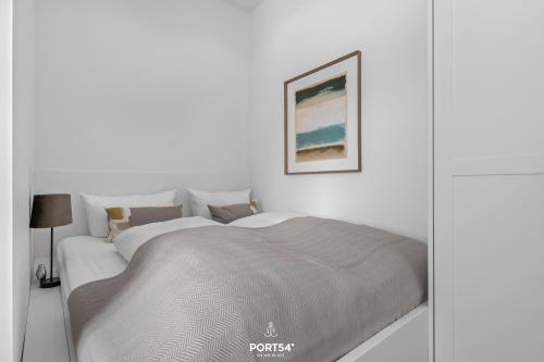 - une chambre blanche avec un lit et une couverture dans l'établissement Ferienwohnung Leichte Brise Westerland auf Sylt, à Westerland