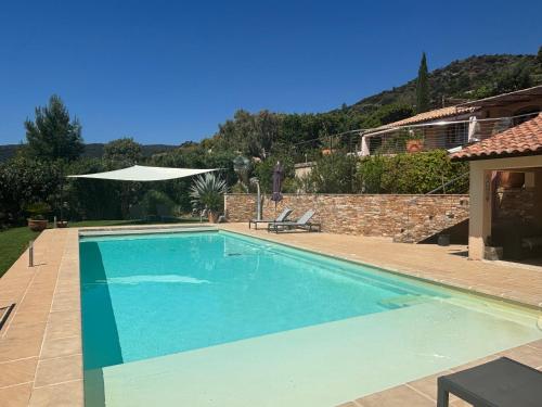 a swimming pool in a yard with a house at Maison vue mer sur les Îles d'Or in Le Lavandou