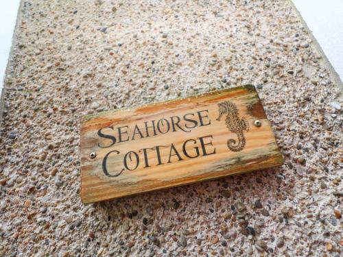 a sign that says seahorse catcher on a counter at Seahorse Cottage in St Ives
