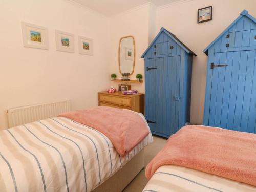 a bedroom with blue doors and a bed and a mirror at Seahorse Cottage in St Ives