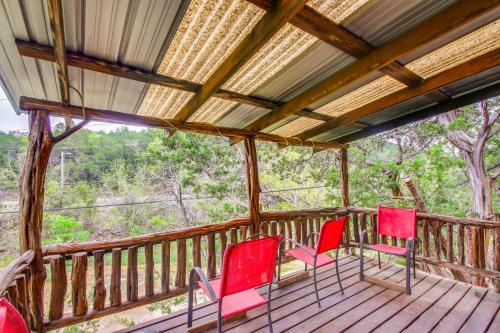 a porch with red chairs on a wooden deck at Cedar Falls Cabin 3 Next to Turner Falls Park in Davis