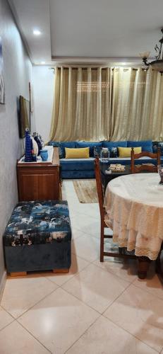 a living room with a table and a couch at appartement el Mansouria Sable d'or in O Ben Slimane