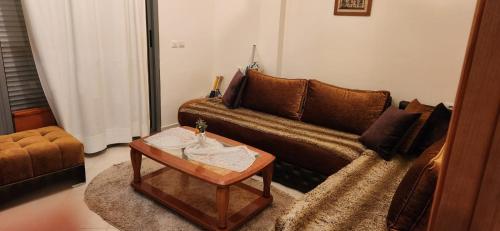 a living room with a couch and a coffee table at appartement el Mansouria Sable d'or in O Ben Slimane