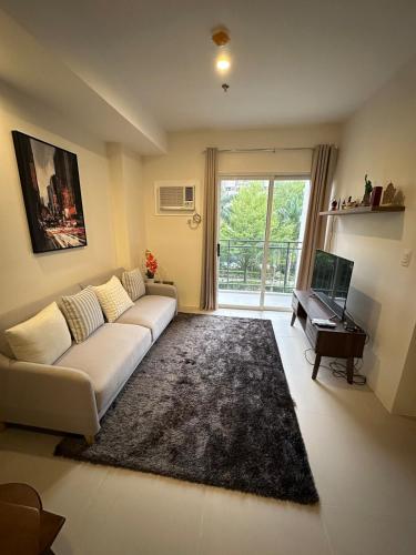 a living room with a white couch and a piano at Condo in Davao City in Davao City