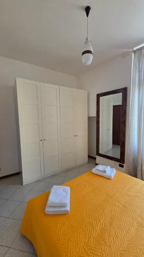 a bedroom with a large yellow bed with a mirror at Casa Amabile in Como
