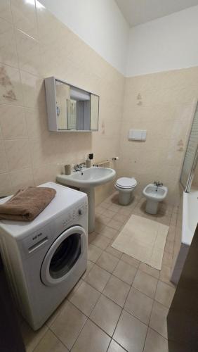 a bathroom with a washing machine and a toilet at Casa Amabile in Como