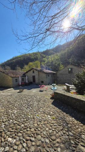 a stone driveway with a building in the background at Borgo Corniola B&B Naturista in Marradi