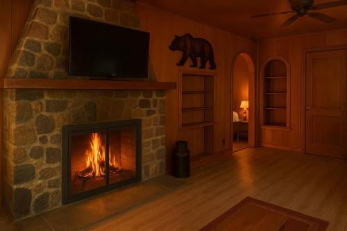 a living room with a fireplace with a television and a bear on the wall at Gresham Shores-Big Dipper #3 in Arbor Vitae