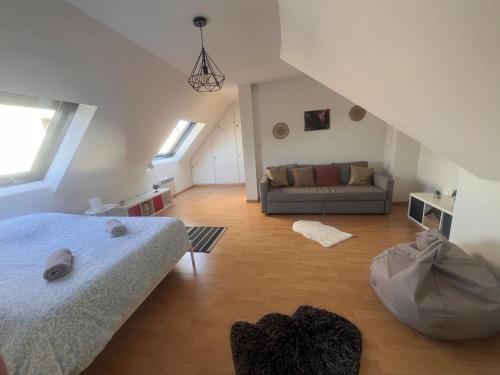 une chambre avec un lit et un canapé dans une pièce dans l'établissement Stras' home, à Strasbourg