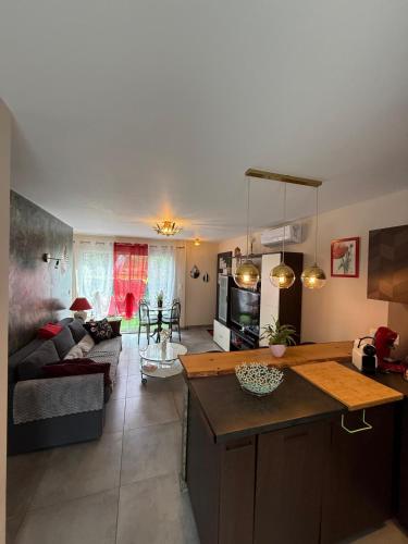 une cuisine et un salon avec un canapé et une table dans l'établissement T2 aile de villa et Spa-jacuzzi privé et illimité et plateau d'acceuil offert!, à Camps-la-Source