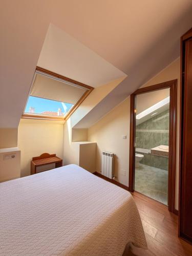 a bedroom with a bed and a large window at Hotel Verdemar in Ribadesella