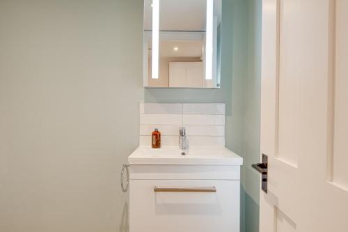 une salle de bains avec un lavabo blanc et un miroir dans l'établissement Old Town Cottage, à Nuneham Courtenay
