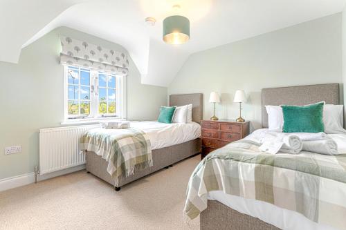 une chambre avec deux lits et une fenêtre dans l'établissement Old Town Cottage, à Nuneham Courtenay