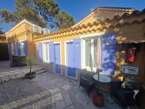 a yellow house with a table in front of it at Le Cosy in Saint-Aygulf