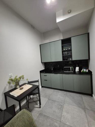 a living room with a table and a kitchen at APARTAMENTY PRUCHNICKA in Jarosław