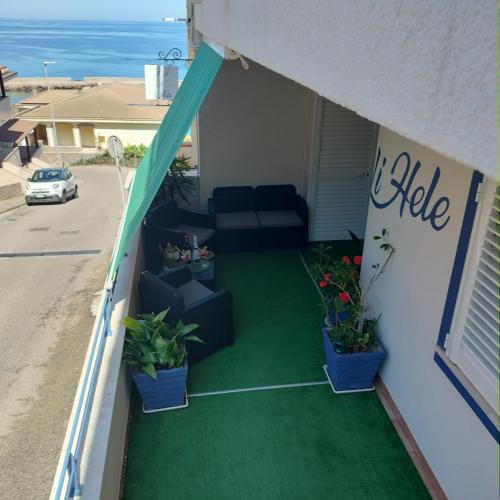 a balcony with a couch and potted plants at Casa Vacanza LiHele - Locazione Turistica in Castelsardo