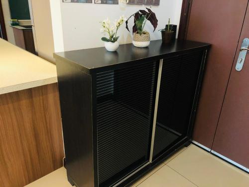 a black cabinet with plants on top of it in a kitchen at Bay Resort condominium Miri in Miri