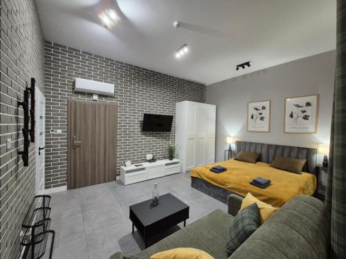 a bedroom with a bed and a couch at APARTAMENTY PRUCHNICKA in Jarosław