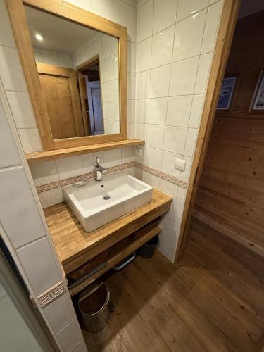 une salle de bain avec un lavabo et un miroir dans l'établissement Le Nid Douillé du Crêt, parking et terrasse, à Val dʼIsère