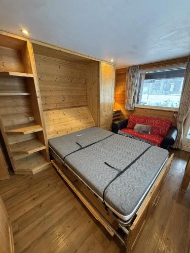 une chambre avec un lit et un canapé dans une pièce dans l'établissement Le Nid Douillé du Crêt, parking et terrasse, à Val dʼIsère