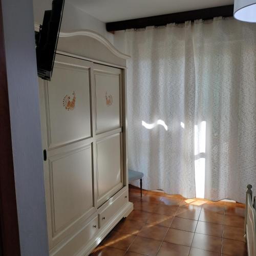 a white cabinet in a room with a window at Casa Vacanza LiHele - Locazione Turistica in Castelsardo