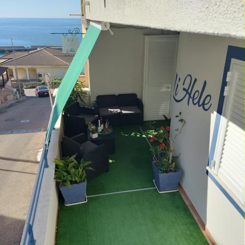a patio with chairs and plants on a balcony at Casa Vacanza LiHele - Locazione Turistica in Castelsardo