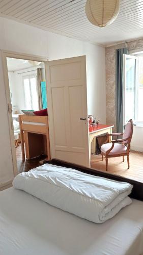 une chambre avec un lit, un bureau et une chaise dans l'établissement Maison entière Guilvinec, au Guilvinec