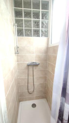 une salle de bain avec une douche avec un lavabo et une fenêtre dans l'établissement Maison entière Guilvinec, au Guilvinec