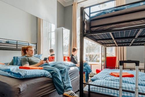 a group of people sitting on bunk beds in a room at Eden Quay Guesthouse Private Rooms in Dublin