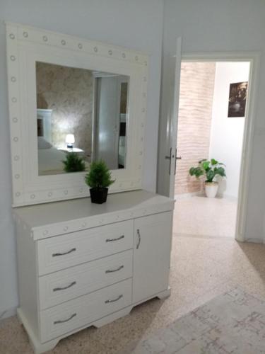 a white dresser with a mirror on top of it at Dar Yassine in Sahline
