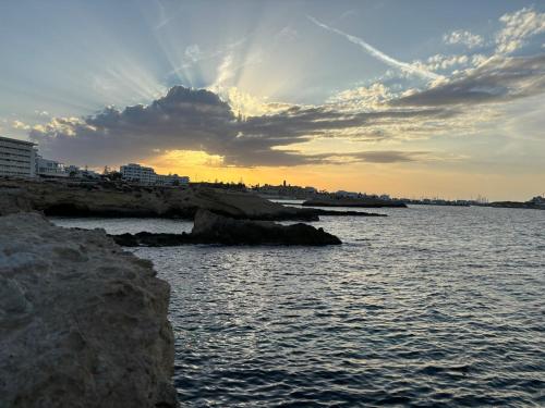 a sunset over a body of water with rocks at Dar Yassine in Sahline
